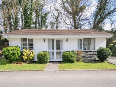 A small white bungalow with a tiled roof and front garden at No 1 The Heathers Rosecraddoc Lodge near Liskeard
