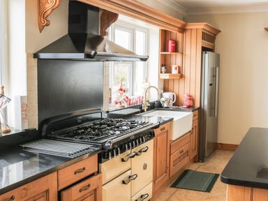 A kitchen with a stove a farmhouse sink wooden cabinets and a refrigerator at McGuire's Cottage Barnatra County Mayo