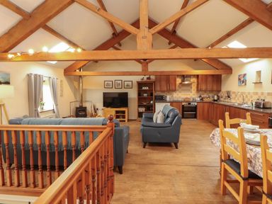 A living room with a kitchen area and seating at Hayloft Cottage Bolton Low Houses
