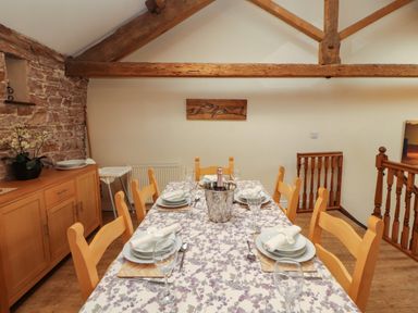 A dining room with a table set for meals at Hayloft Cottage Bolton Low Houses