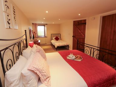 A bedroom with two beds and a tray of breakfast items at Horseshoe Cottage in Bolton Low Houses