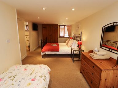 A bedroom with double and single beds at Horseshoe Cottage in Bolton Low Houses