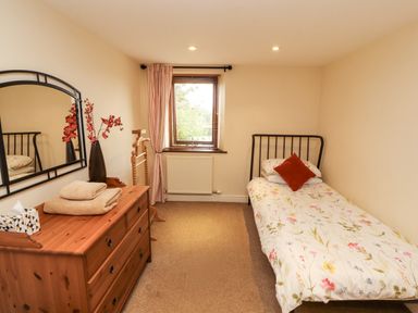 A bedroom with a bed and dresser at Horseshoe Cottage in Bolton Low Houses