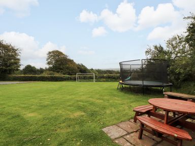 A garden with a trampoline and a goalpost at Horseshoe Cottage in Bolton Low Houses