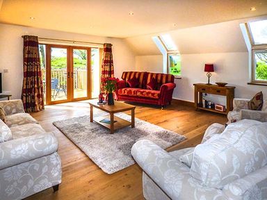 A living room with sofas coffee table and a sideboard at Brynhir Farm in Howey near Llandrindod Wells