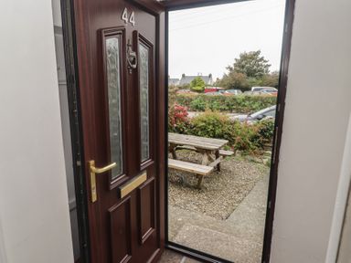 An entrance with a door and a bench outside at Garth Cottage Haverfordwest