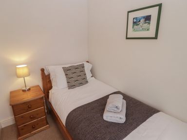 A bedroom with a single bed and nightstand at Garth Cottage Haverfordwest