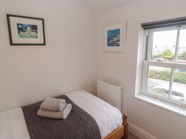 A bedroom with a bed and framed artwork at Garth Cottage Haverfordwest