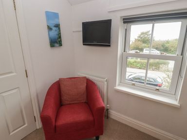 A living room with an armchair and television at Garth Cottage Haverfordwest