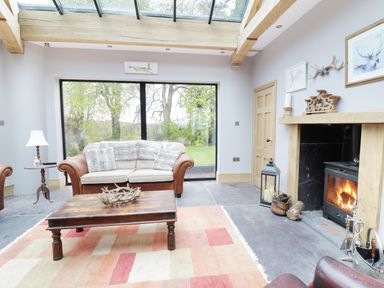 A living room with a sofa table and fireplace at Bryn Derwen Bethesda near Caernarfon