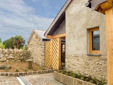 An outdoor area with stone walls wooden gate and planter at Tyn Y Celyn Uchaf in Clocaenog near Ruthin