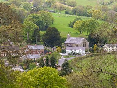 A village with houses and a church surrounded by green fields and trees at Tyn Y Celyn Uchaf in Clocaenog near Ruthin