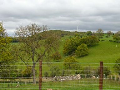A view of green hills and trees with a wire fence in the foreground at Tyn Y Celyn Uchaf in Clocaenog near Ruthin