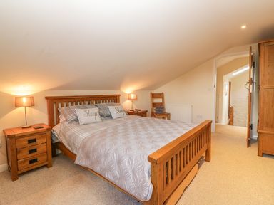 A bedroom with a wooden bed and bedside tables with lamps at Higher Whiddon Farm Whiddon Well Ashburton near Newton Abbot