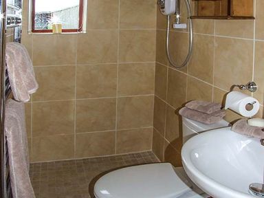 A bathroom with a toilet sink towels and a window at Owl Cottage in Napton-on-the-Hill near Southam