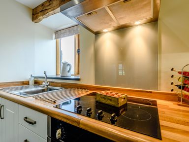 A kitchen countertop with a sink stove and a crate of eggs near a window at The Stables in Llanfair Caereinion near Welshpool