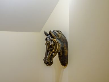 A horse head sculpture mounted on a corner wall at The Stables Llanfair Caereinion near Welshpool