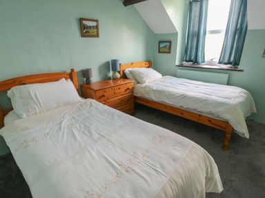 A bedroom with two beds and a window at Glan y Gors Dinorwic near Llanberis