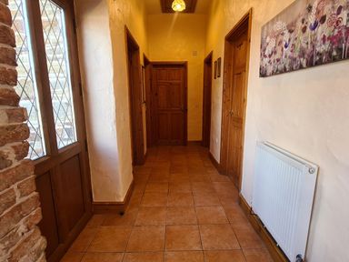 A hallway with tiled floor wooden doors and a white radiator at Swallow Cottage in Llanboidy