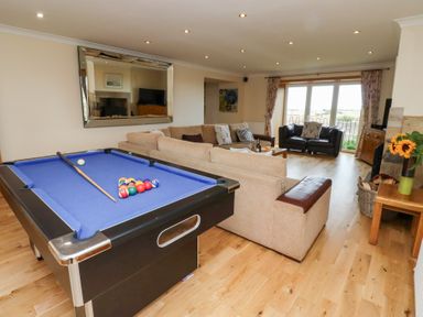 A living room with a pool table and seating area at Granary Stone House in Embleton
