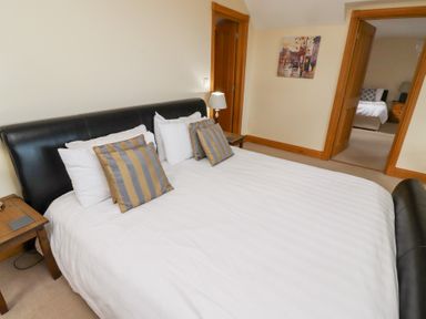 A bedroom with a bed and lamp at Granary Stone House in Embleton