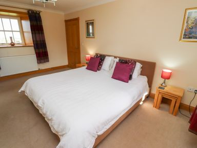 A bedroom with a bed and nightstand at Granary Stone House in Embleton