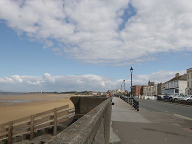 A promenade beside a sandy beach with street lamps and buildings along a road at Pear Tree Cottage in Mark near Burnham-on-Sea