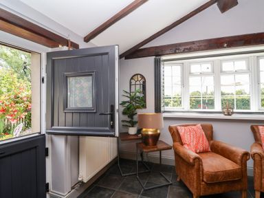 An entrance area with a door and armchairs at Pear Tree Cottage Mark near Burnham-on-Sea