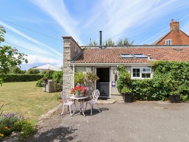 An outdoor seating area with table and chairs at Pear Tree Cottage Mark near Burnham-on-Sea