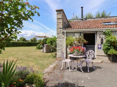 An outdoor area with a table and chairs at Pear Tree Cottage near Burnham-on-Sea