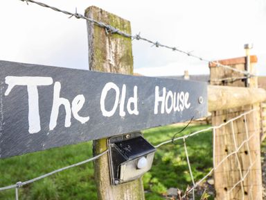 A fence with a sign that reads The Old House and a small light attached at The Old House in Llanidloes