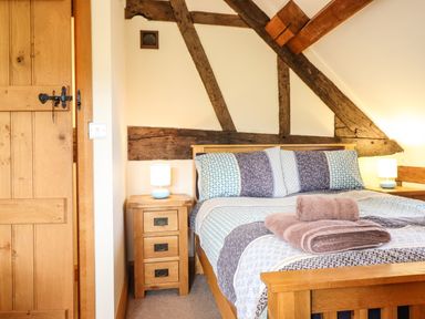 A bedroom with a wooden bed and bedside tables with lamps at The Old House in Llanidloes