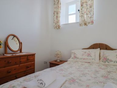 A bedroom with a bed and dresser at West Bowden Farm Knowstone near South Molton