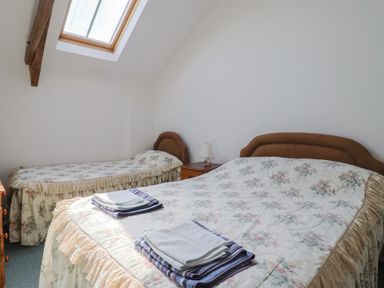 A bedroom with two beds and a lamp on a bedside table at West Bowden Farm Knowstone near South Molton