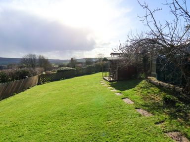 A garden with grass, a shed, and a path at Heather Croft in Robin Hood's Bay