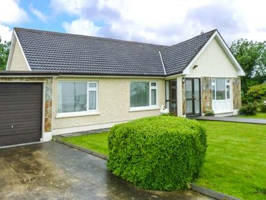 A bungalow with a driveway and trimmed bush in front at Eileen's Aughavas near Mohill County Leitrim