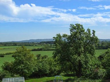 A landscape with trees green fields and a playground frame at Cotswold View in Clifford Chambers near Stratford-upon-Avon