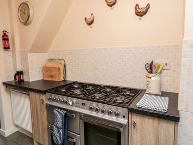 A kitchen with a gas stove oven cutting boards and cooking utensils at Bunty's Place Chatton near Wooler