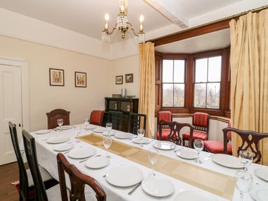 A dining room with a long table set for a meal and chairs around at Eden House Edenhall near Penrith