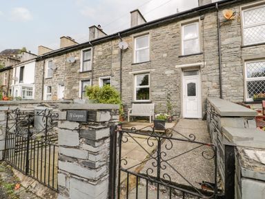Stone terraced houses with front gardens and metal gates at Ty Gwynn in Tanygrisiau