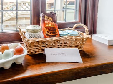 A basket with cookies and jars and a carton of eggs on a wooden windowsill at Willow Cottage in Ulrome near Skipsea