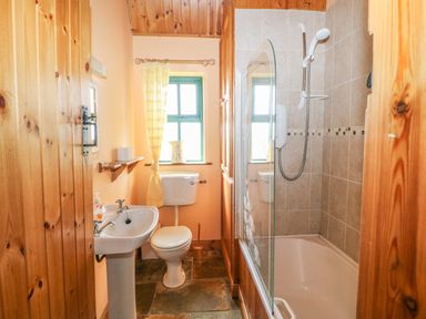 A bathroom with a sink toilet and bathtub with shower at An Nead in Ballinknockane near Dingle County Kerry