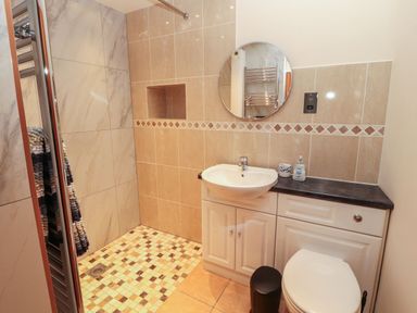A bathroom with a shower, sink, and toilet at Sonya's Cottage in Anthorn, Solway Firth