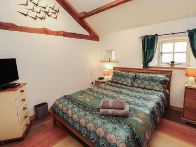 A bedroom with a bed and television at Sonya's Cottage Anthorn, Solway Firth