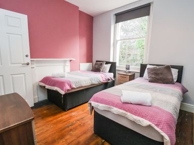 A bedroom with two single beds and a window at Mountain View in Penmaenmawr