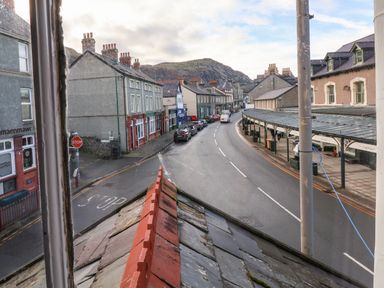 A street view with parked cars and buildings along the road at Mountain View in Penmaenmawr