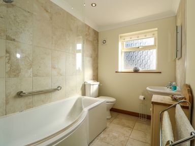 A bathroom with a bathtub a toilet a sink and a window at Sunnyside Cottage in Blackborough End near Kings Lynn
