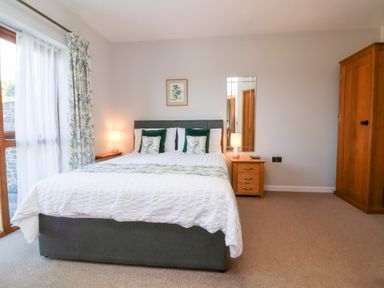 A bedroom with a bed and lamp at Pound Cottage in Huntshaw near Great Torrington