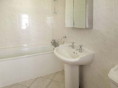 A bathroom with a bathtub a pedestal sink and a wall-mounted mirror cabinet at Treetops in Govilon near Abergavenny