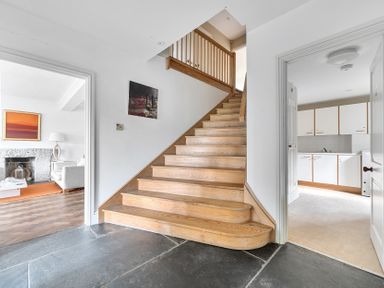 A hallway with a staircase and kitchen view at Cragford in Sennen Cove